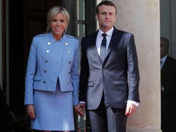 French President Emmanuel Macron poses for photographers with his wife Brigitte