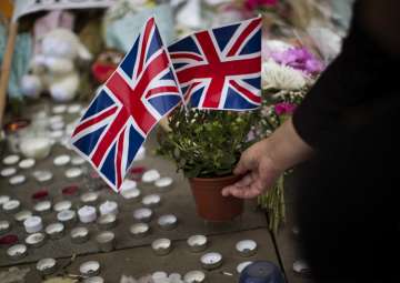 A woman places flowers in Albert Square in Manchester