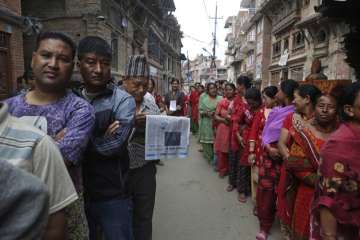 Nepalese stand in a queue to cast their votes during the local election