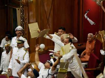 Marshals protecting UP Governor Ram Naik from paper balls thrown by MLAs