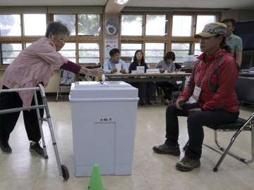 A woman casts her ballot for presidential election at a polling station in Seoul