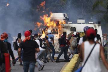 Anti-govt protesters set fire to an armored vehicle in Caracas, Venezuela