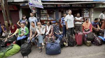 Stranded tourists wait at a bus stand in Darjeeling