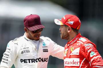 Lewis Hamilton of Great Britain talks with Sebastian Vettel of Germany