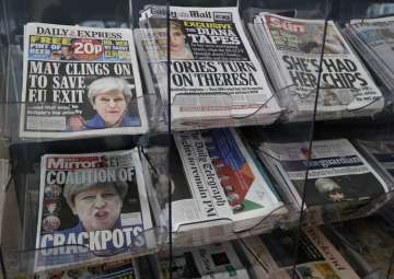 Newspapers fronted with photos of May are displayed at a shop in London