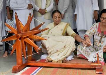 Meira Kumar tries her hand on a spinning wheel during her visit to Gandhi Ashram