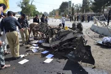 Pakistani police officers examine the site of an explosion in Quetta