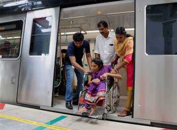 Differently abled passenger being helped during 'sneha yathra' in Kochi Metro