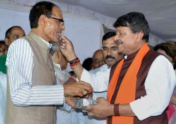 Kailash Vijaywargiya offers sweet to Shivraj Singh Chouhan to break his fast