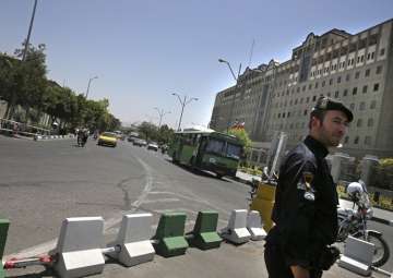 A police officer stands guard in front of Iran’s parliament building in Tehran
