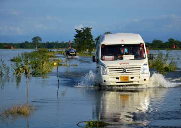People travel in a mini bus at flood-hit Jamlai village in Assam's Kamrup