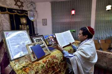 Priest Ezekiel Markel reads religious books at Judah Hyam Synagogue in Delhi 
