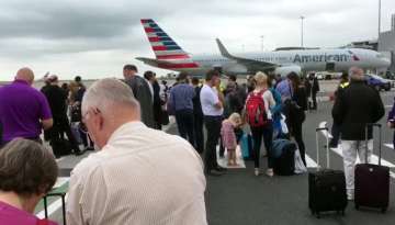Passengers stand on the tarmac after being evacuated at Manchester Airport