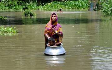 A woman with her child in flood affected Khanamukh village in Morigoan, Assam