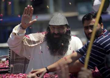 Syed Salahuddin waves to his supporters as he arrives in Muzaffarabad