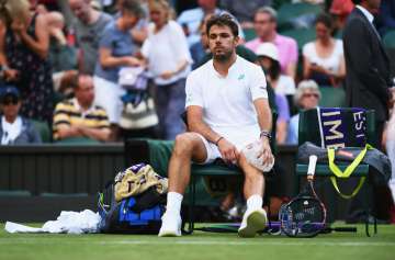 Stan Wawrinka of Switzerland puts ice on his knee during the first round