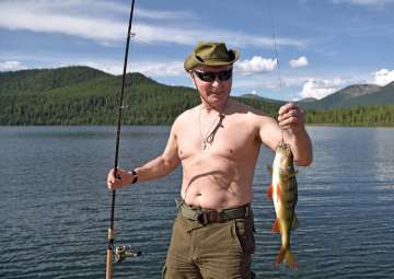 Putin holds a fish he caught during a mini-break in Siberian Tyva region