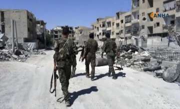 US-backed fighters patrol a street in Raqqa, Syria
