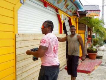 Men board up buildings ahead of Hurricane Maria.