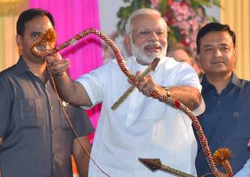 PM Modi holds a bows and arrow during Dussehra celebrations