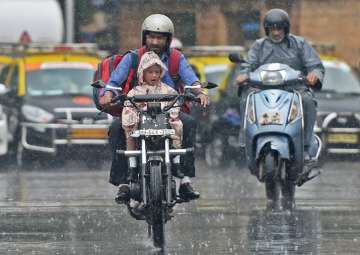 Mumbai: A man carries his child home from school on a motorcycle