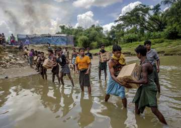 Rohingyas carry food items across from Bangladesh towards a refugee camp