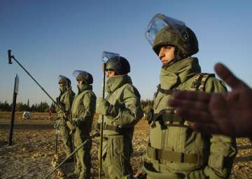 Trainees of a bomb disposal unit prepare to practice a bomb search near Homs