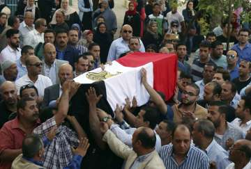 People carry the coffin of a policeman killed in an ambush with terrorists in al-Wahat al-Bahriya area in Giza province