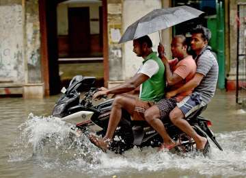 People on a motorcycle wade through a flooded street in Kolkata on Monday.