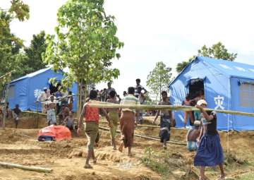 File pic - People walk near Chinese relief tents at a camp in Cox's Bazaar district, Bangladesh