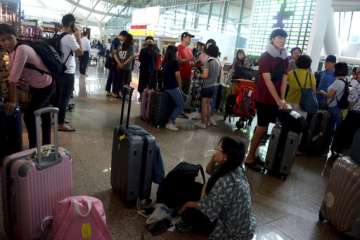 Tourists wait as Ngurah Rai International Airport