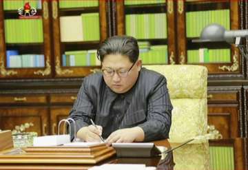 North Korea's leader Kim Jong Un signing what is said to be a document authorising a missile test. 