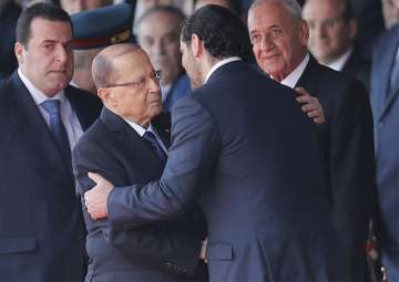 Lebanese President Michel Aoun is greeted by PM Saad Hariri upon their arrival to attend a military parade to mark the 74th anniversary of Lebanon independence