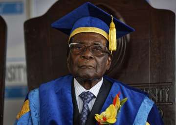 Zimbabwe's President Robert Mugabe sits for formal photographs with university officials, after presiding over a student graduation ceremony at Zimbabwe Open University