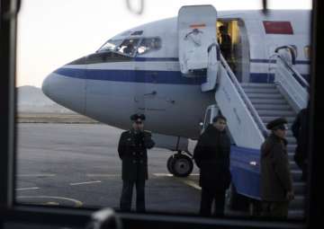 File - North Korean officials wait for passengers to board an Air China flight at Pyongyang airport in Pyongyang