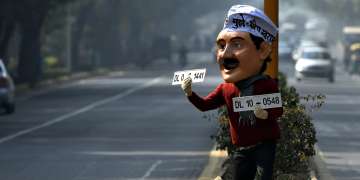 File photo of a man dressed as Delhi CM Arvind Kejriwal displaying number plates to explain how odd-even will work.