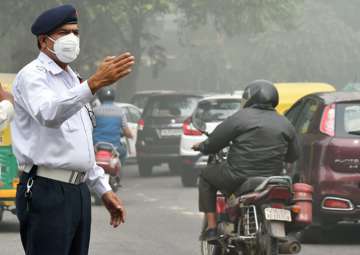 Traffic policemen wear masks to protect themselves from heavy smog and air pollution while manning the traffic in Delhi