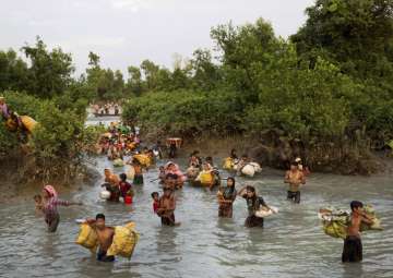 Rohingya wade through the Naf river after having just crossed over from Myanmar into Bangladesh, near Palong Khali