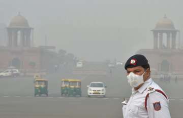A traffic policeman mans traffic amid smog and air pollution at Vijay Chowk in New Delhi on Monday.