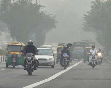 People commute during the foggy in New Delhi on Saturday.