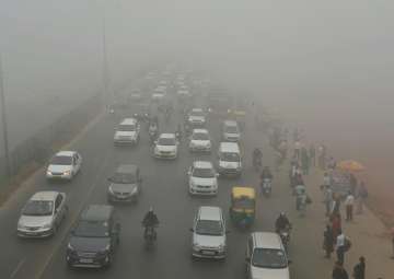 Vehicles plying at a road in smog, in New Delhi 
