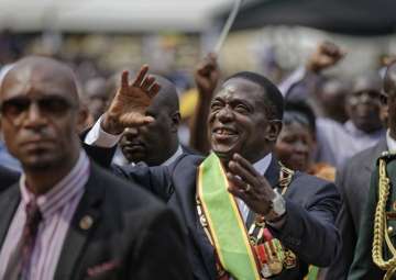 Zimbabwe’s President Emmerson Mnangagwa gestures to the cheering crowd as he leaves after the presidential inauguration ceremony in the capital Harare on Nov 24