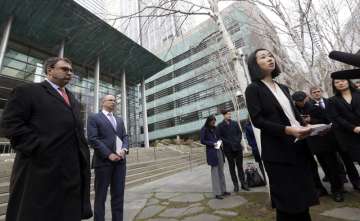 Mariko Hirose, right, a litigation director at the Urban Justice Center, speaks to reporters accompanied by Mark Hetfield, president & CEO of HIAS, left, and Rabbi Will Berkowitz, Jewish Family Service of Seattle CEO, in front of a federal courthouse in Seattle.