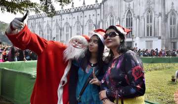 Kolkata: A man dressed as Santa takes selfie at St. Paul's Cathedral during Christmas celebrations