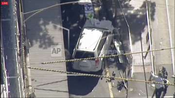 A white SUV vehicle is stopped after allegedly striking pedestrians.