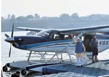 PM Narendra Modi waves to the crowd as he boards a seaplane on the Sabarmati river front in Ahmedabad.