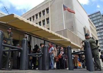 File - An Israeli border policemen guards the US Embassy in Tel Aviv as other Israelis line up for US visas