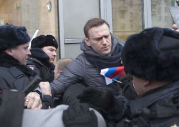 Russian opposition leader Alexei Navalny, centre, is detained by police officers in Moscow, Russia