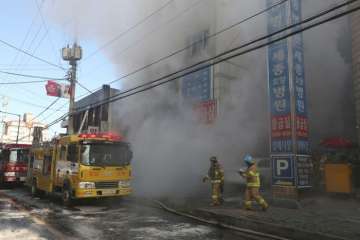 Firefighters work as smoke billows from the Sejong Hospital. 