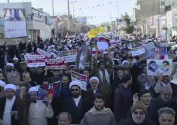 This frame grab from video provided by Iran Press, a pro-government news agency based in Beirut, shows pro-government demonstrators marching in Qom